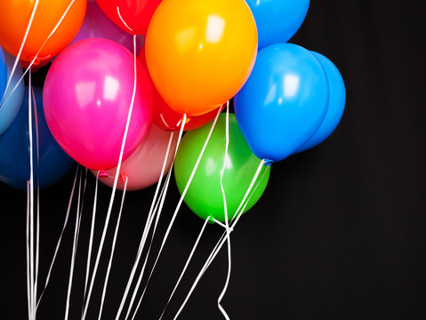 Fototapeta Group of colorful balloons on ribbons over black