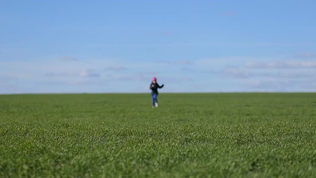 Girl runs in the grass field