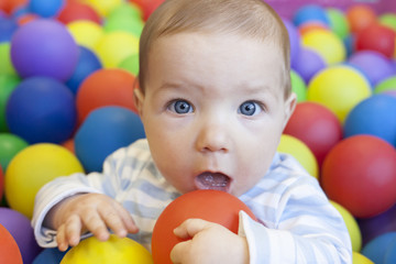 Fototapeta na wymiar baby boy playing in the playground balls pool