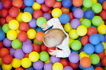 Fototapeta na wymiar baby boy playing in the playground balls pool