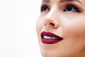 beautiful brunette girl in a black dress smiling. lips painted purple lipstick 