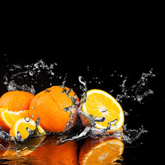 Obraz na płótnie Canvas Orange fruits and Splashing water