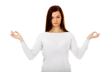 Young woman makes meditating gesture