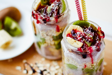 Healthy breakfast over night oats with fresh fruit kiwi and bananas in a glass jar. Beautiful oatmeal