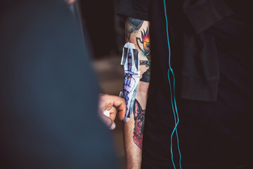 Master tattoo artist showing process of transfer tattoo sketch on a hand using special thermal paper.