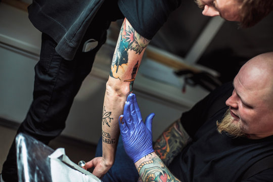 master tattooist gets a healing ointment on the skin after the tattooing