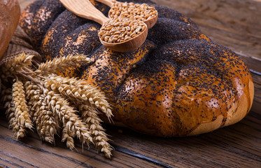 Assortment of baked bread on wooden table background