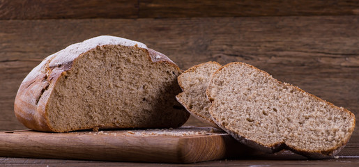 Assortment of baked bread on wooden table background