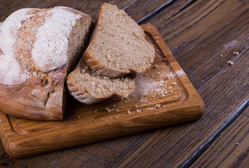 Assortment of baked bread on wooden table background