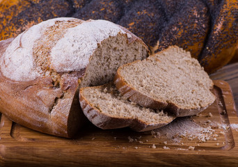 Assortment of baked bread on wooden table background