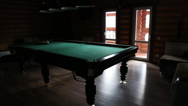 Billiards table and balls in a dark room
