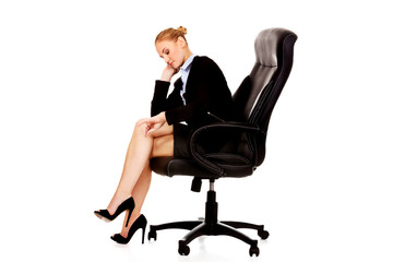 Tired or worried business woman sitting on armchair