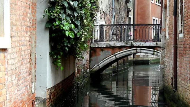 Canal with small bridge in Venice, Italy.