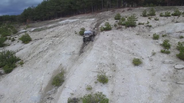 Aerial 4k video of offroad contest/ Drone flying over the offroad UTV and follow it