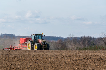 Fototapeta premium Tractor harrowing the field
