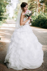Fototapeta premium Beautiful bride woman portrait with bridal bouquet posing in her