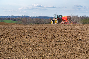 Fototapeta premium Tractor harrowing the field