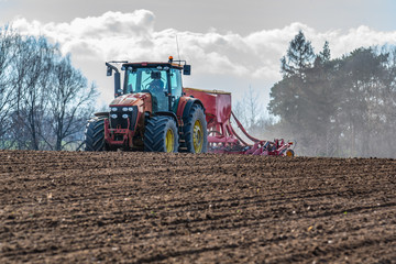 Fototapeta premium Tractor harrowing the field