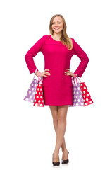 Shopper girl in pink dress holding plastic bags isolated on whit