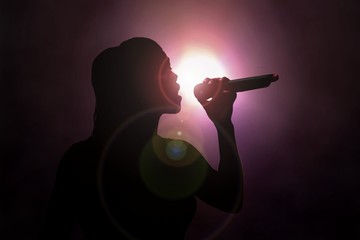 Women singing under spotlight