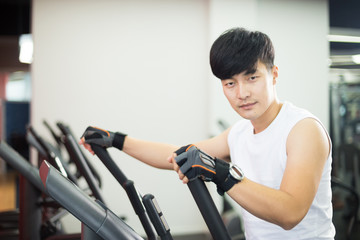 young handsome asian man works out in modern gym