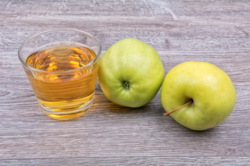 Apples and juice on a wooden background