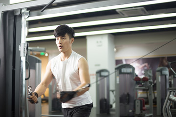 young handsome asian man works out in modern gym