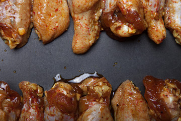 Marinated chicken wings on a black pan