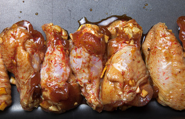 Marinated chicken wings on a black pan