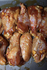 Marinated chicken wings on a black pan