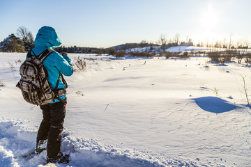Fototapeta na wymiar Woman Snowshoeing in Winter time Landscape