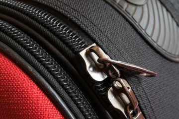 two zipper on red and black luggage back