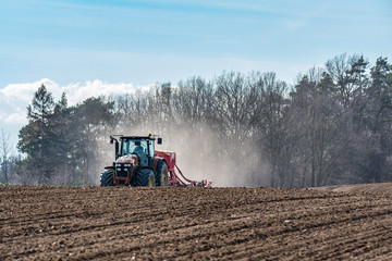 Fototapeta premium Tractor harrowing the field