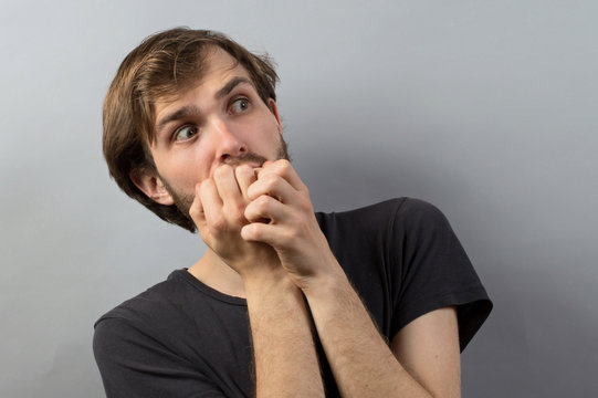 young business man biting his nails. on a light gray studio background
