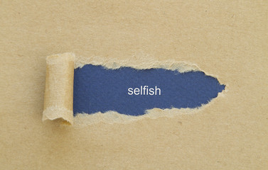 Selfish word written under torn paper.