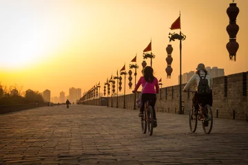 Peel and stick wall murals China XIAN, CHINA - MARCH 13 2016: People ride bicycle on City Wall of  Xi'an famous Historic Sites in china sunset in the evening