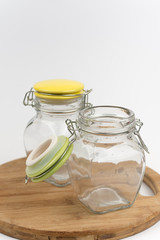 Two empty glass jars on the wooden board