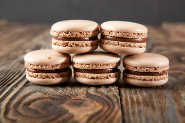 Chocolate macaroons and black chocolate on old wooden table