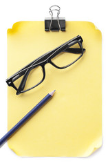 glasses and pencil on blank paper