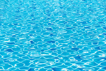 blurred of blue swimming pool with sunny reflections