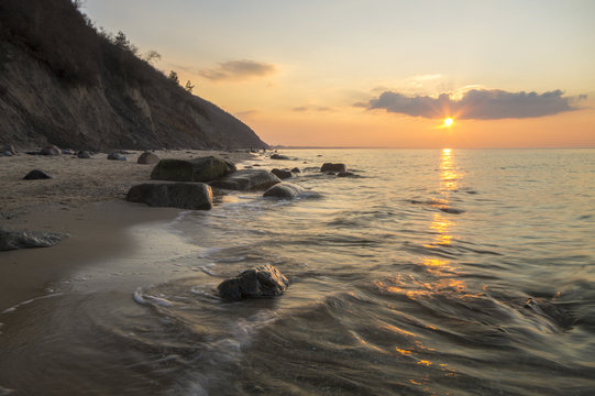 Fototapeta Klif i plaża morska w świetle zachodzącego słońca