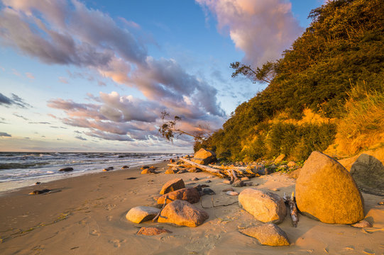 Fototapeta Klif i plaża morska w świetle zachodzącego słońca