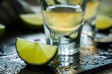 Gold tequila shots on rustic wood background