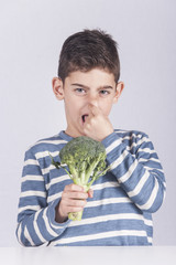 Little boy making a funny face refusing to eat his vegetables
