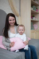 Funny playful mum with baby toddler at home