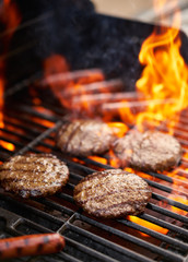 hamburgers and hot dogs being grilled - obrazy, fototapety, plakaty