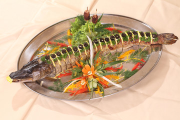 pike baked in the oven, served with lemon and olives
