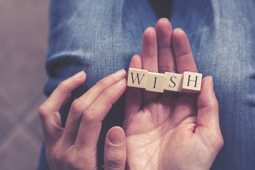 Hands holding Wish message formed with wooden blocks
