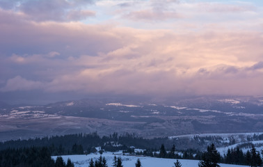 Beautiful evening winter landscape in the Carpathians mountains. Dramatic overcast sky