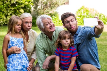 Obraz premium Happy father taking selfie with family in yard
